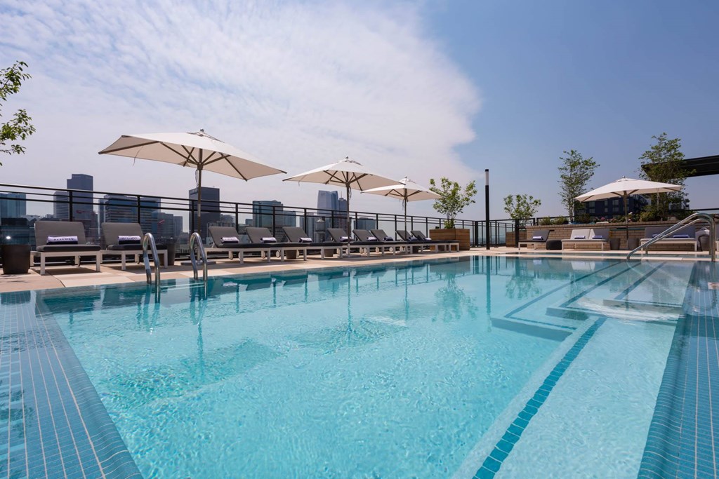 a swimming pool with lounge chairs and umbrellas at a hotel