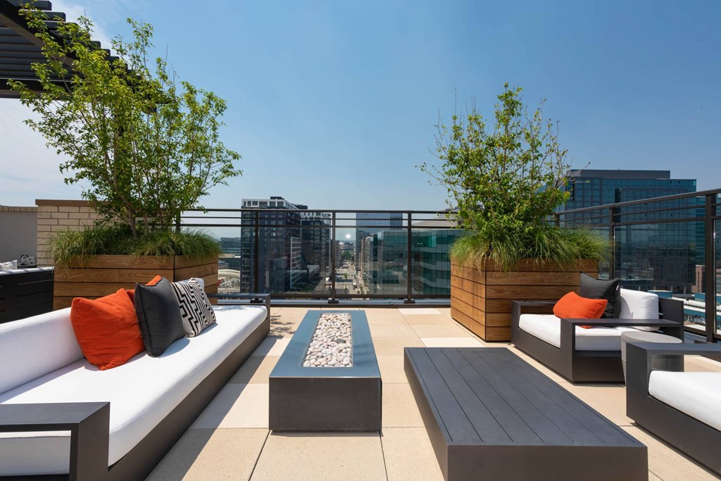 a rooftop patio with couches and tables and plants