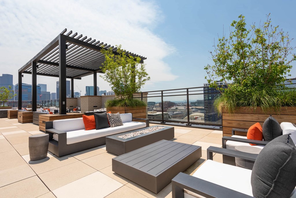 a roof top patio with furniture and a view of the city