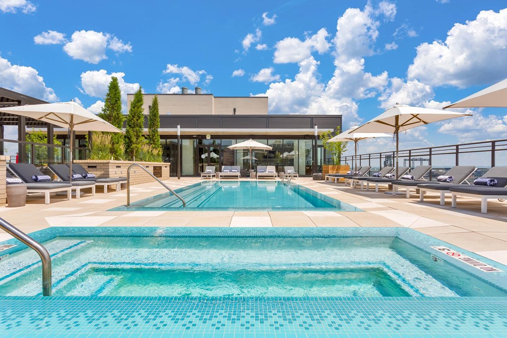 a swimming pool at a hotel with chairs and umbrellas