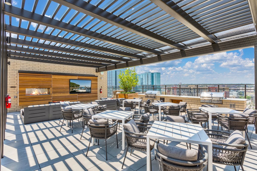 a patio with tables and chairs and a view of the city