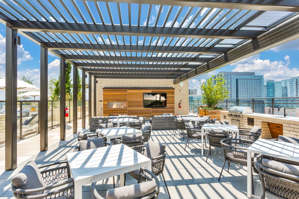 a patio with tables and chairs and a view of the city
