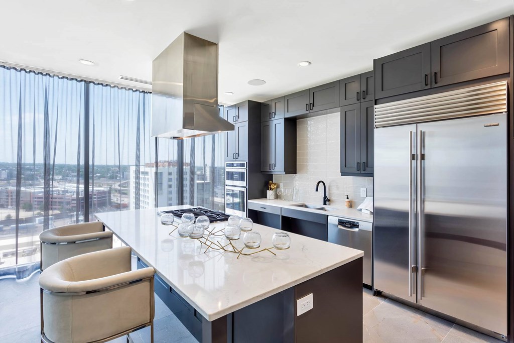 a kitchen with a large island and stainless steel appliances