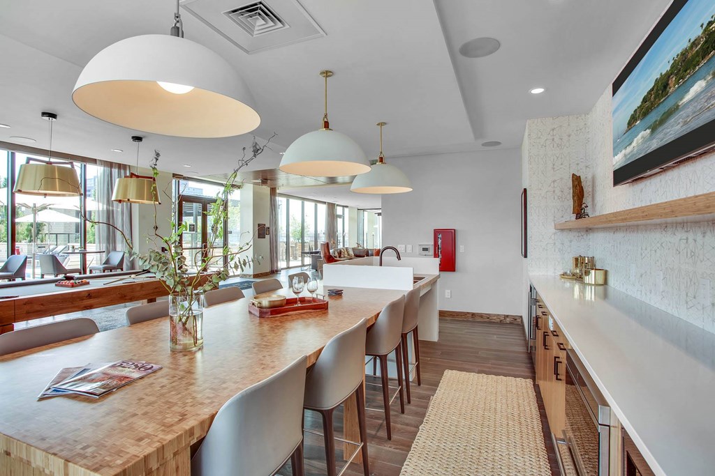 a kitchen with a long counter and a long bar with chairs