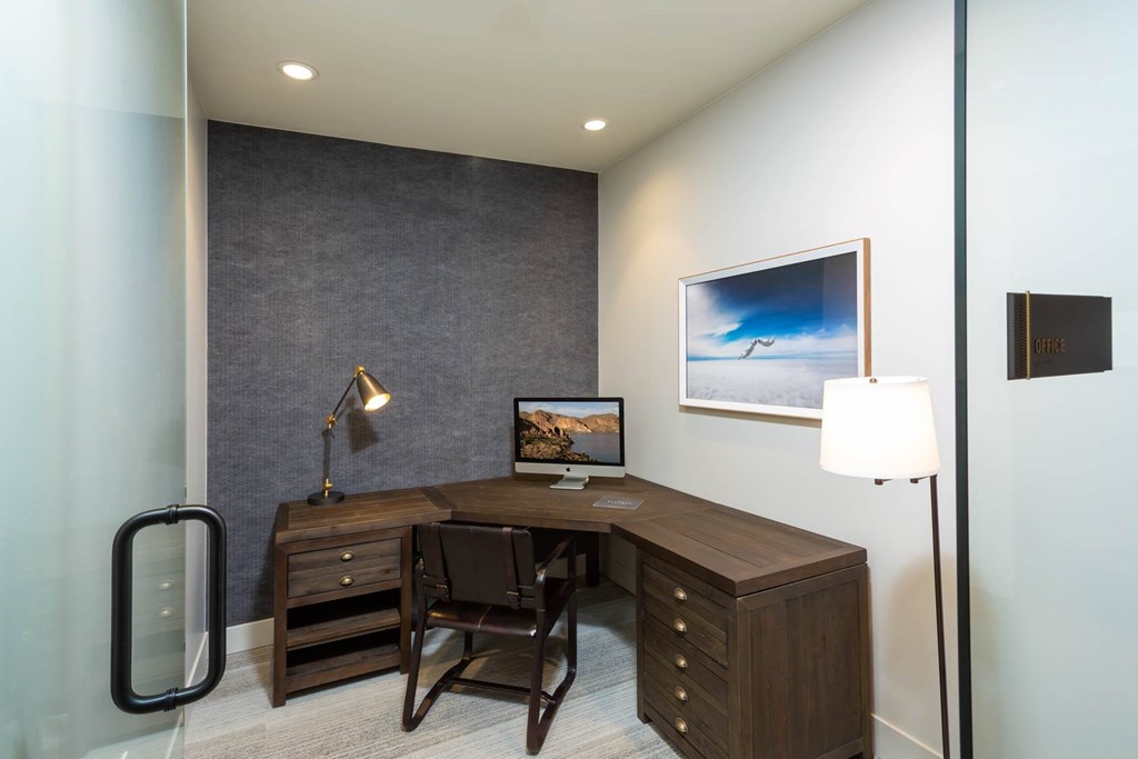 a home office with a desk and a painting on the wall