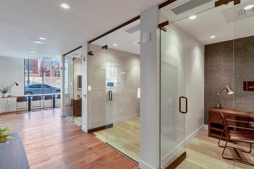 a conference room with glass walls and a desk