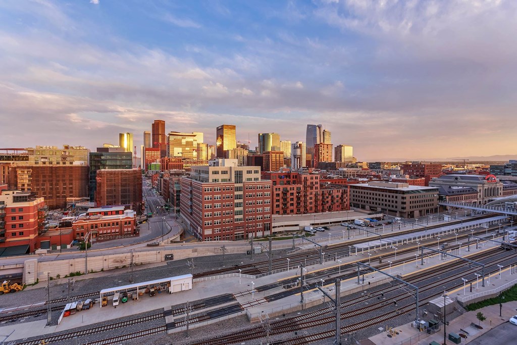 a view of the city skyline at sunset with train tracks
