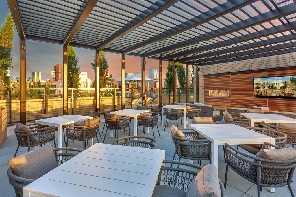 a patio with tables and chairs and a view of a city