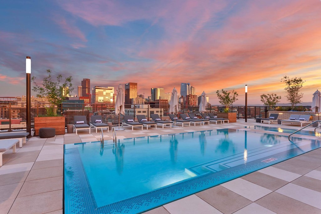 the pool at the envoy hotel with the city skyline in the background