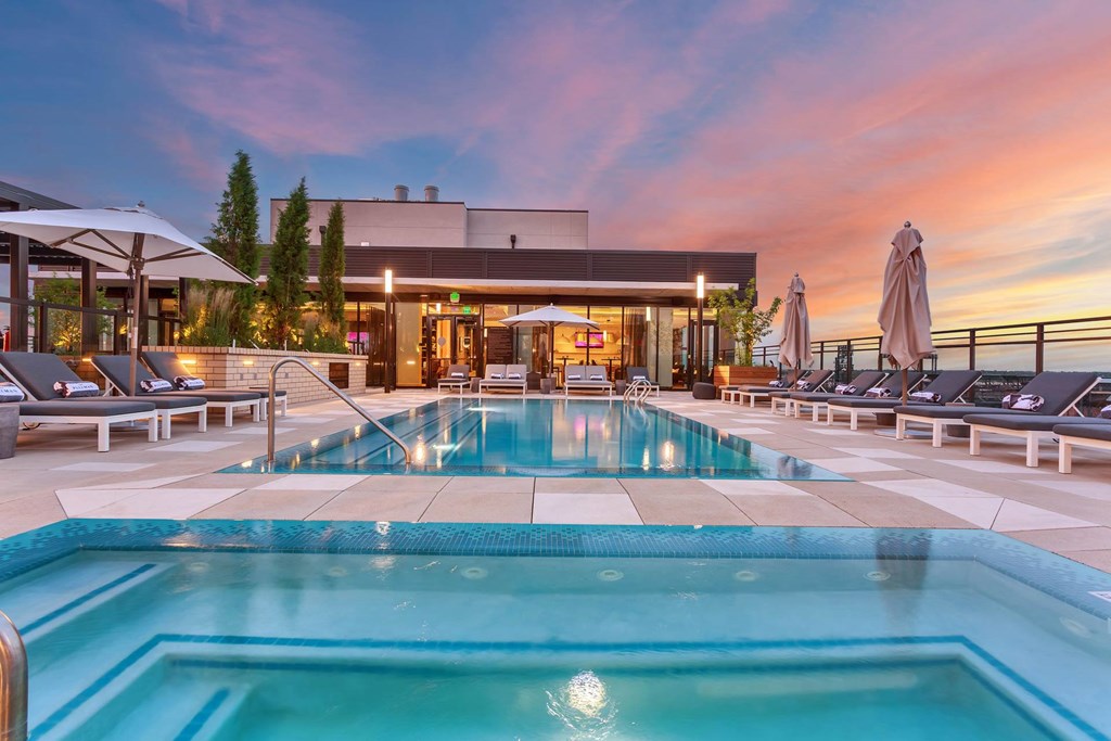 a swimming pool at a hotel with a sunset in the background