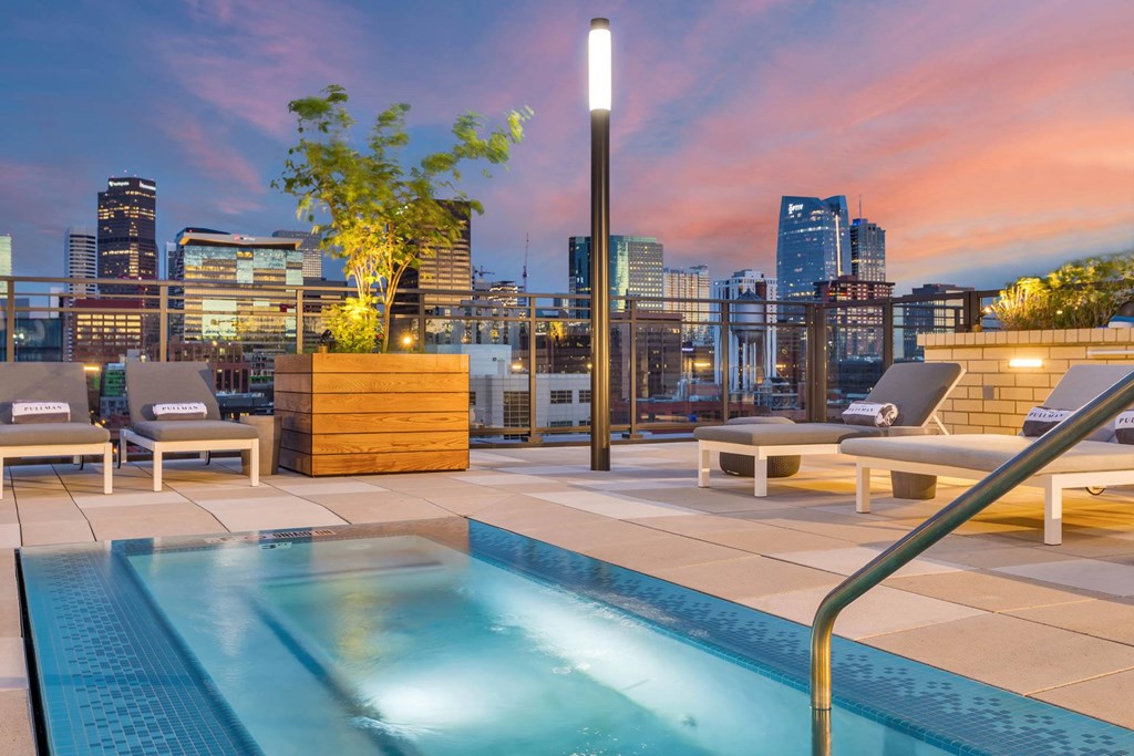 a rooftop pool with a city skyline in the background