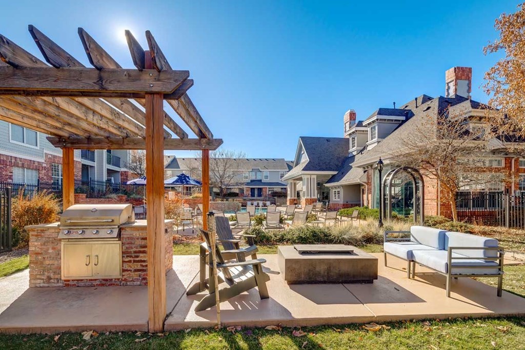 a backyard with a barbecue grill and a patio with a table and chairs