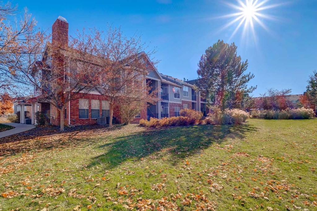 a large brick house with the sun shining in front of it