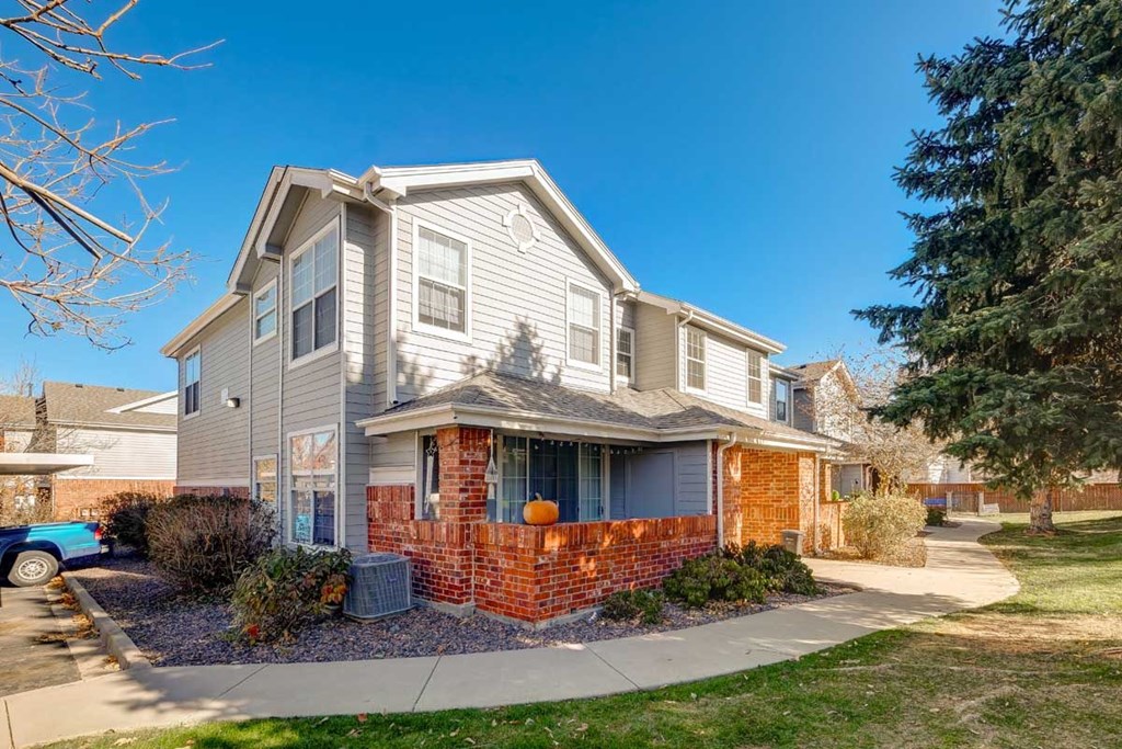 the front of a house with a sidewalk in front of it