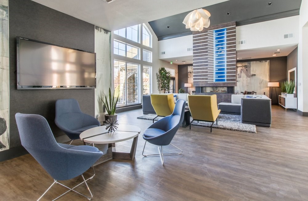 a living room with chairs and tables and a fireplace