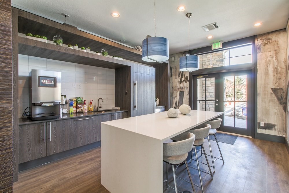 a kitchen with a white counter and a bar with stools