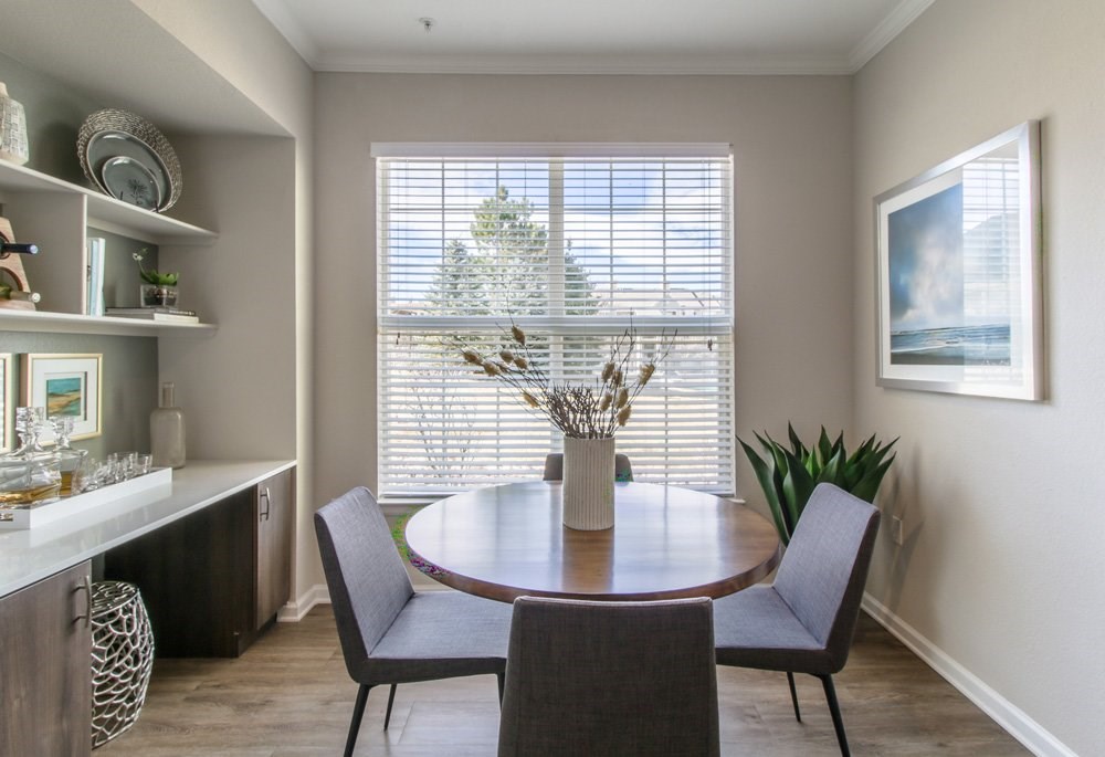 a dining room with a large window and a table with chairs