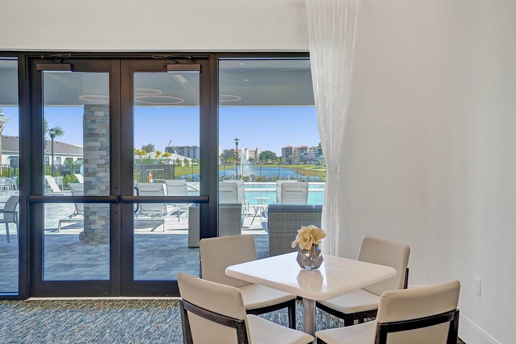 a dining room with a view of the water and a table and chairs