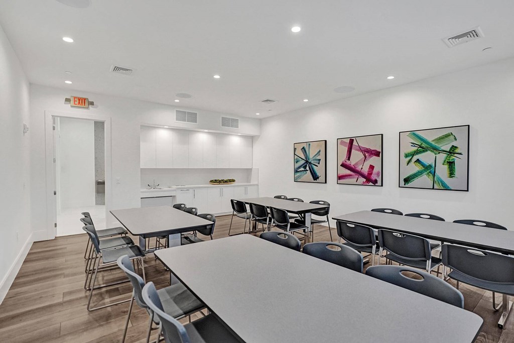 a dining room with tables and chairs and a kitchen