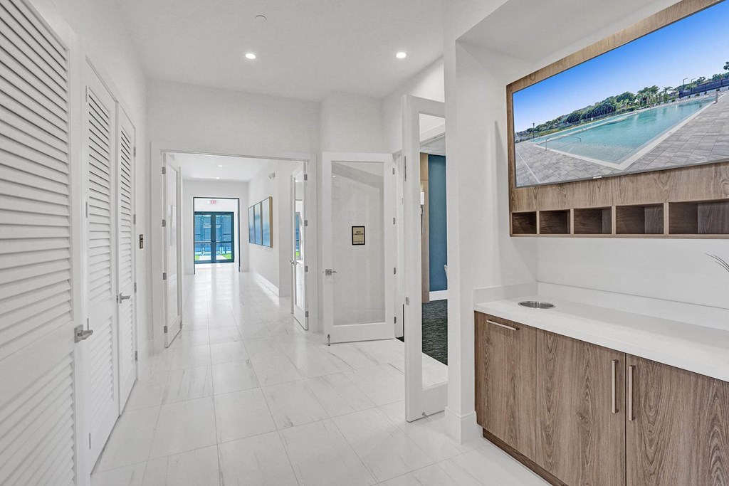 a long white hallway with a tv on the wall