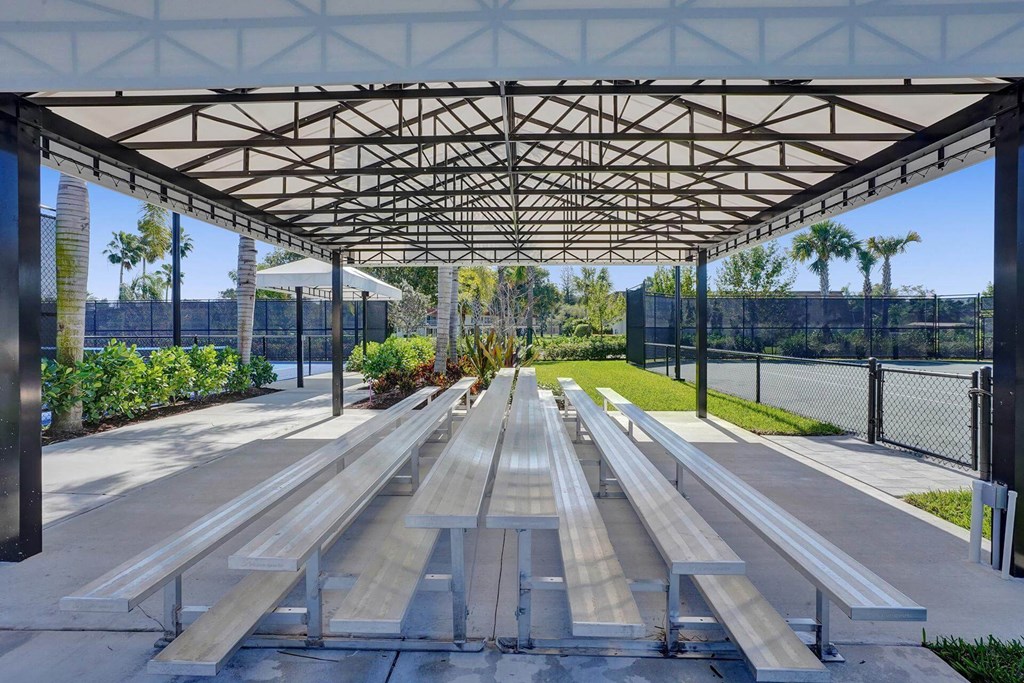a picnic area with benches under a canopy