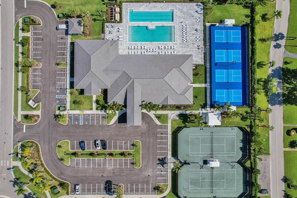 arial view of a building with a parking lot and a pool