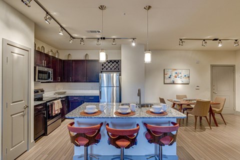 A kitchen with a table and chairs in the middle of it.