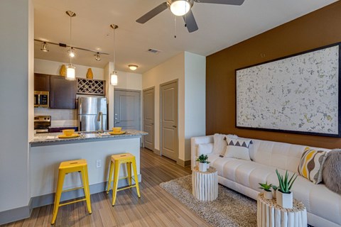 A kitchen with a bar and a couch in the living room.