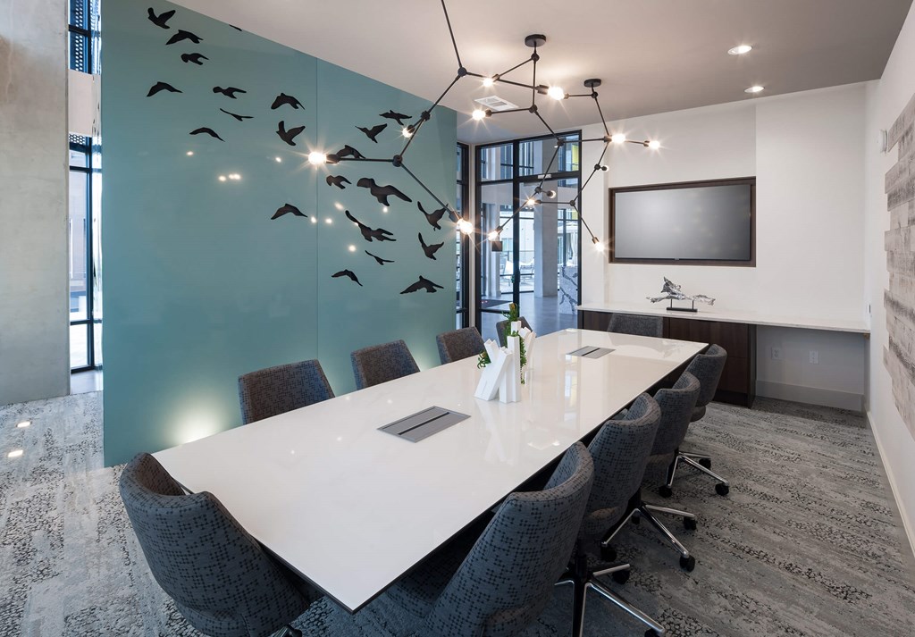 a conference room with a long white table and chairs