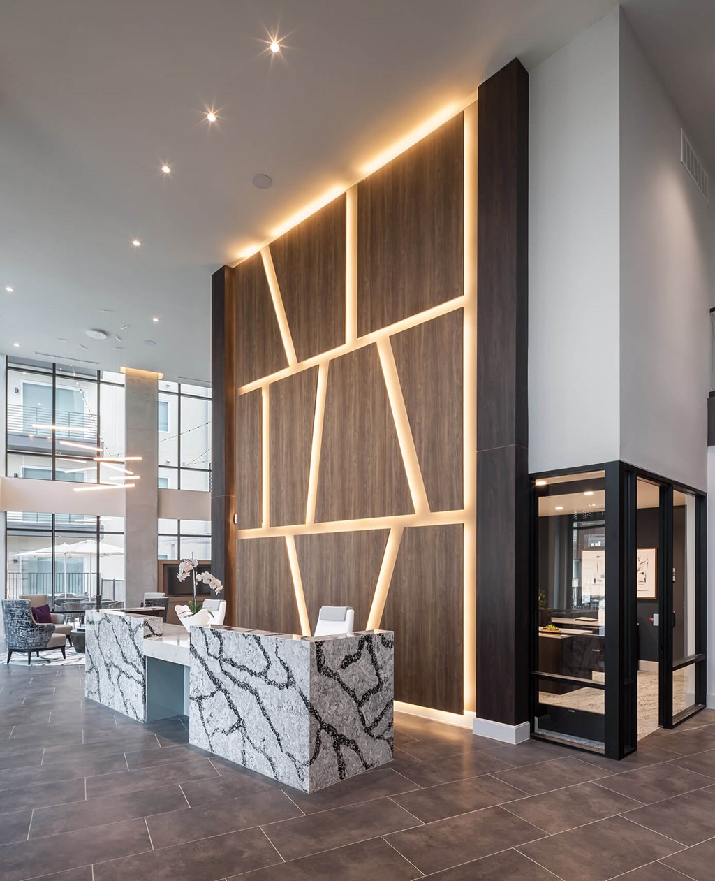 a lobby with a reception desk and a large wooden feature wall