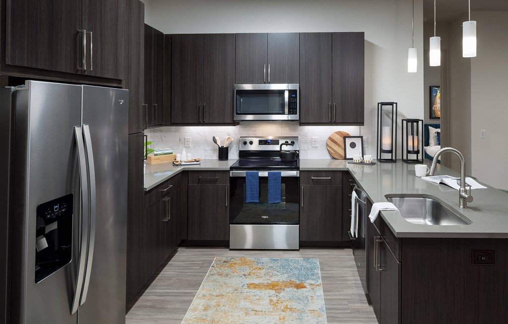 a kitchen with stainless steel appliances and dark wood cabinets