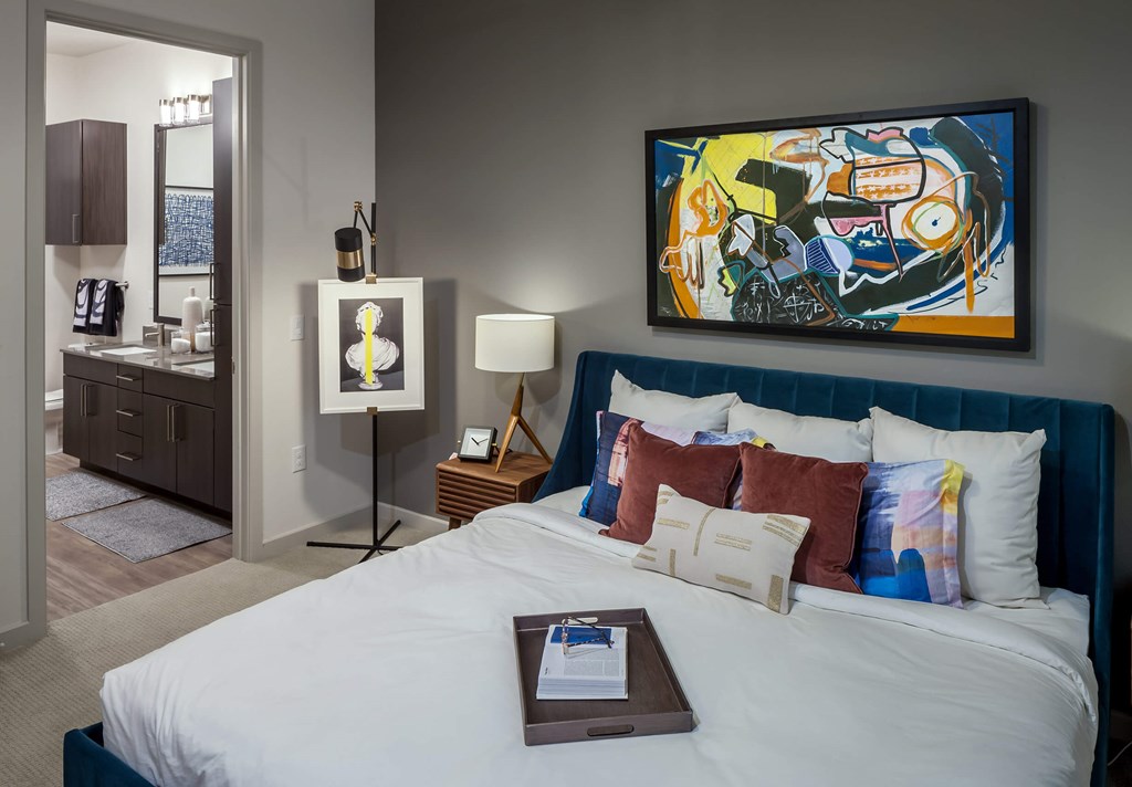 a bedroom with a large bed and a painting on the wall