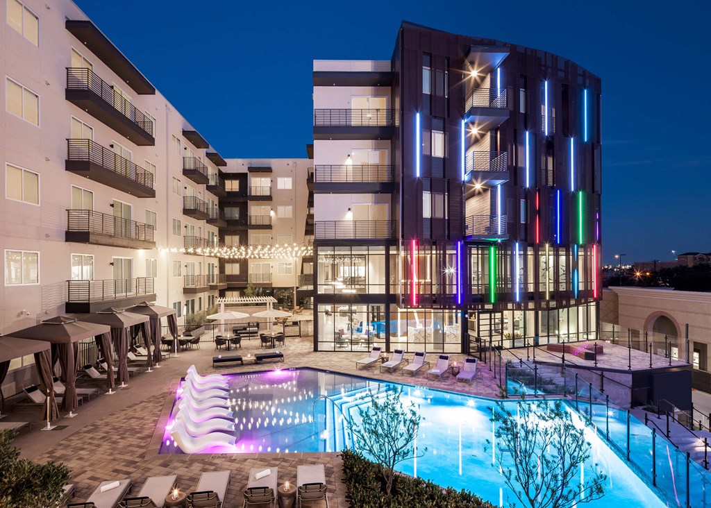 a building with a pool in front of it at night