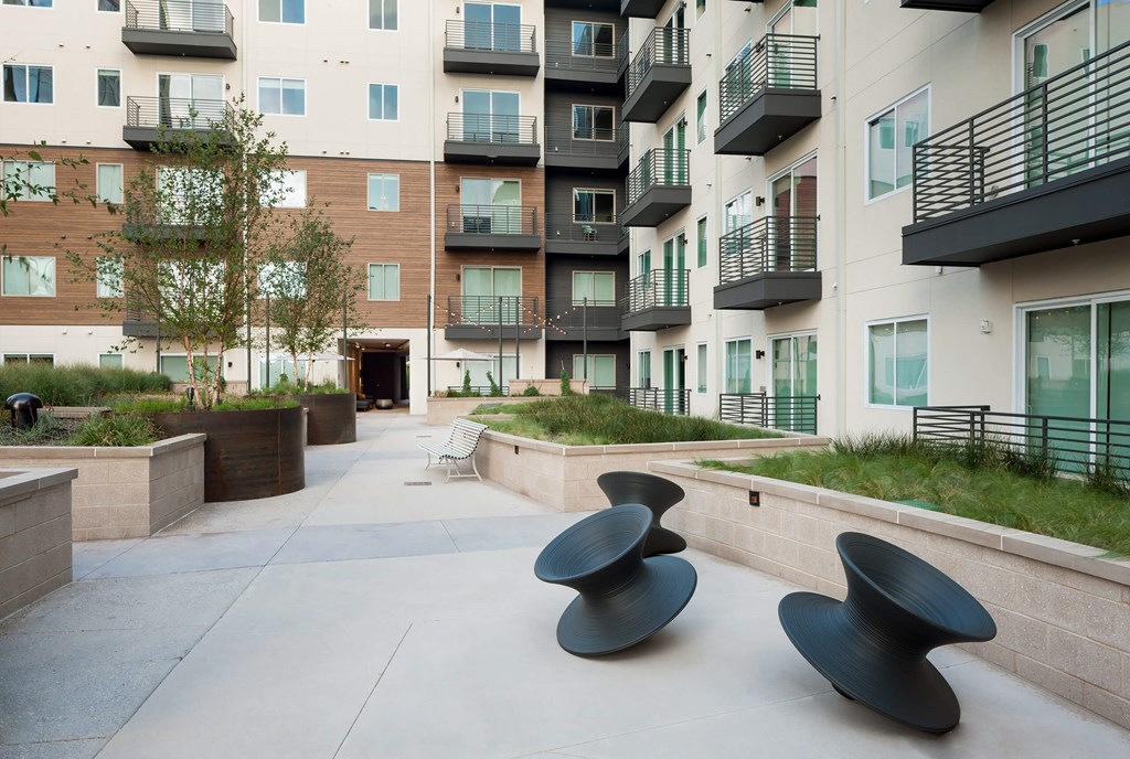an outdoor area with benches and an apartment building