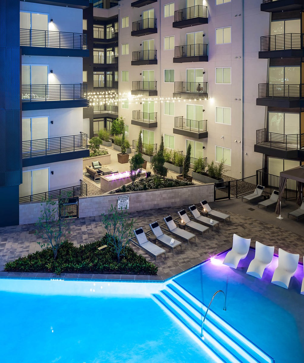 an outdoor pool with an apartment building in the background