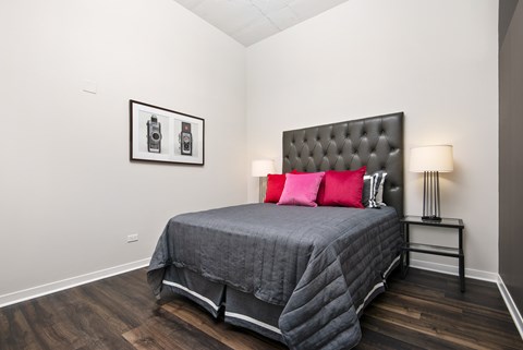 a bedroom with a bed with red pillows