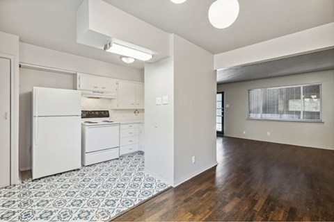 A kitchen with white appliances and a blue and white tiled floor.
