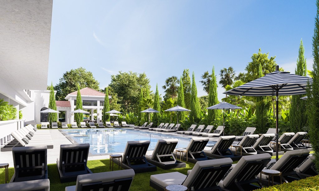 a pool with lounge chairs and umbrellas at a hotel