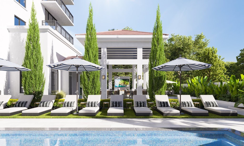 a swimming pool with lounge chairs and umbrellas next to a poolside hotel