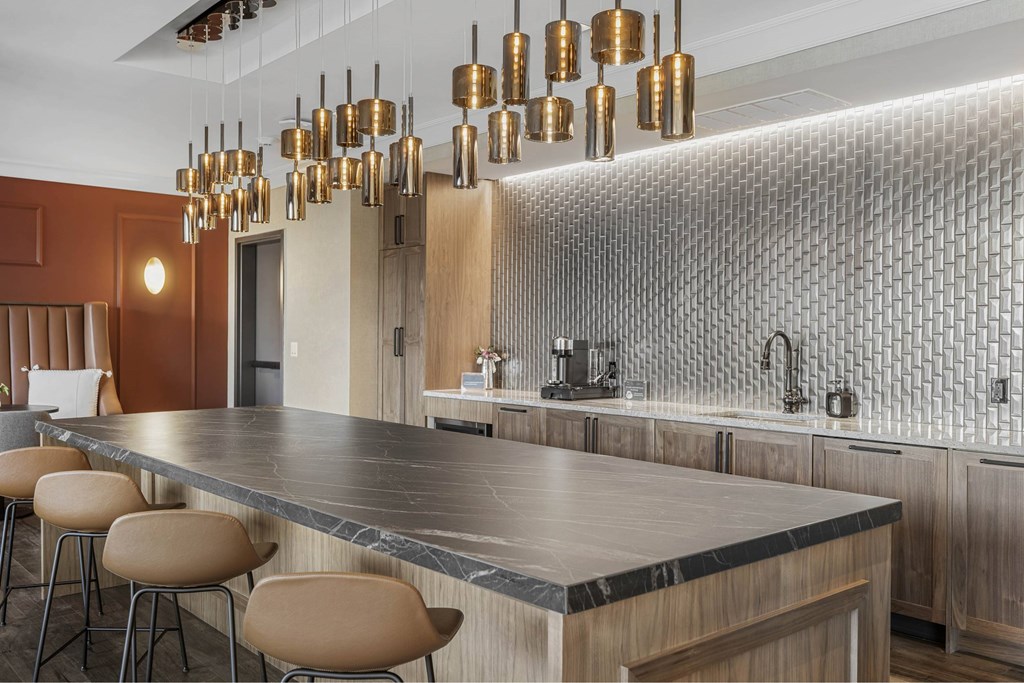 a kitchen with a long counter and chairs and a sink