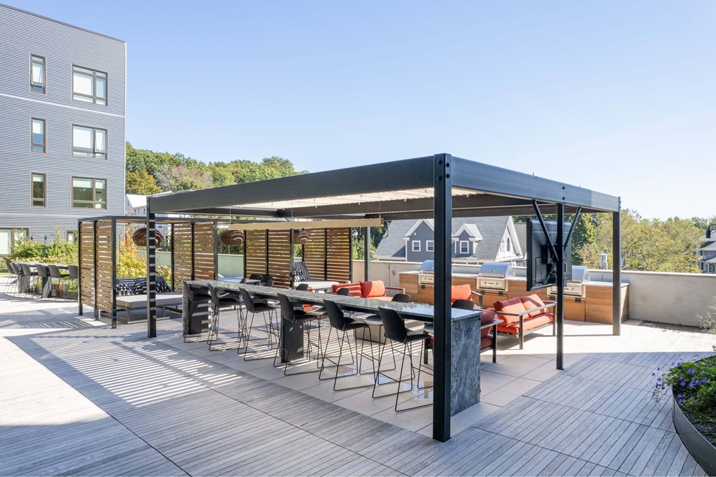 a rooftop patio with a bar and a table with chairs