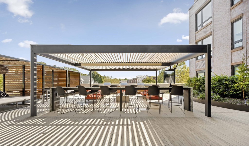 a patio with tables and chairs and a pergola