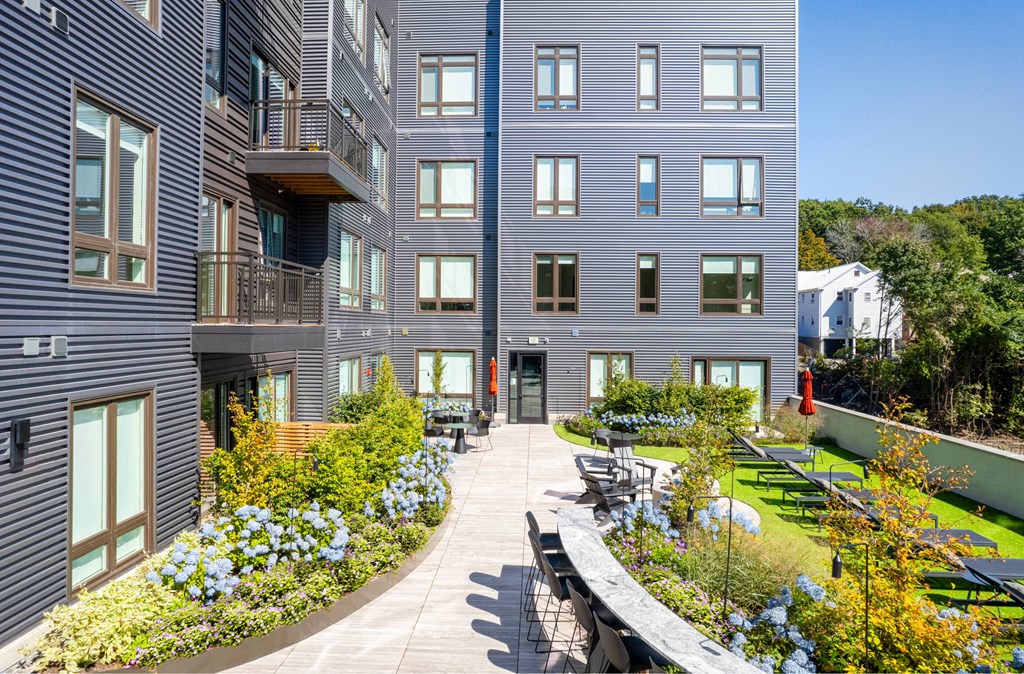 a large courtyard with tables and chairs in front of a building