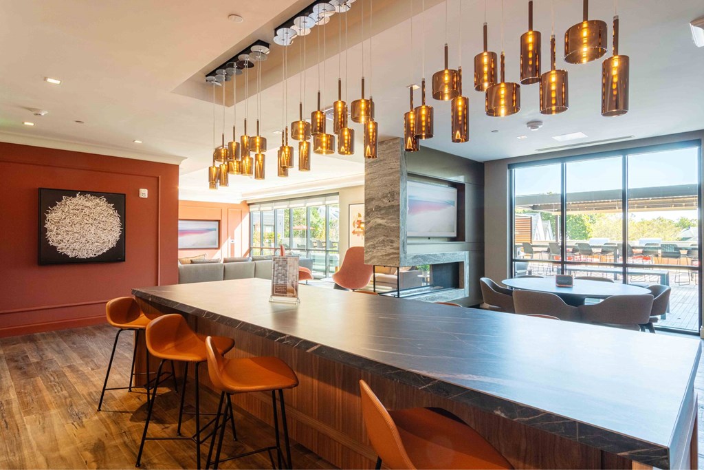 a long communal table in a restaurant with orange chairs