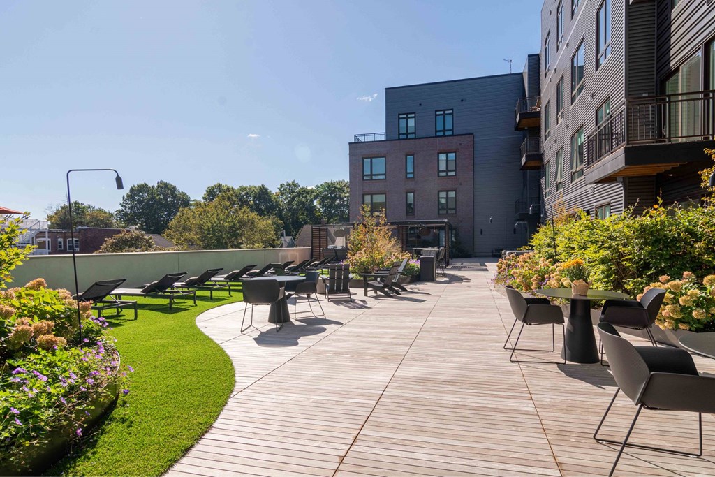a large patio with tables and chairs on a roof terrace