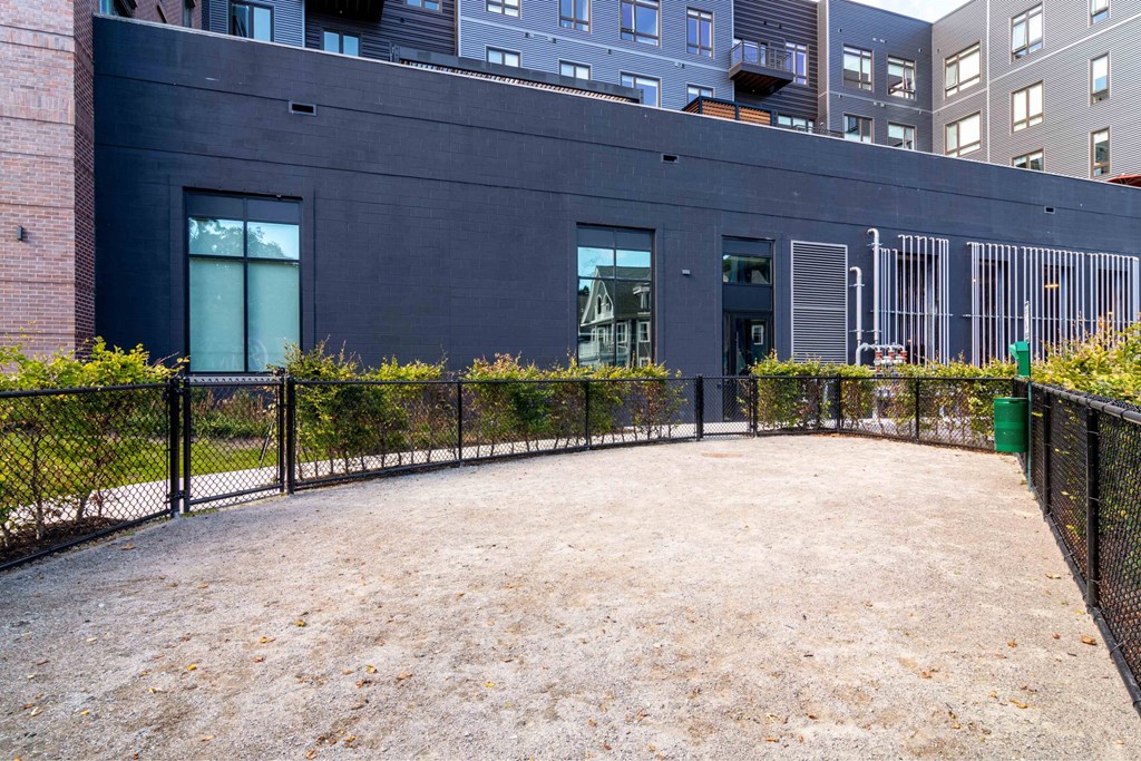 the courtyard of a building with a gravel area and a fence
