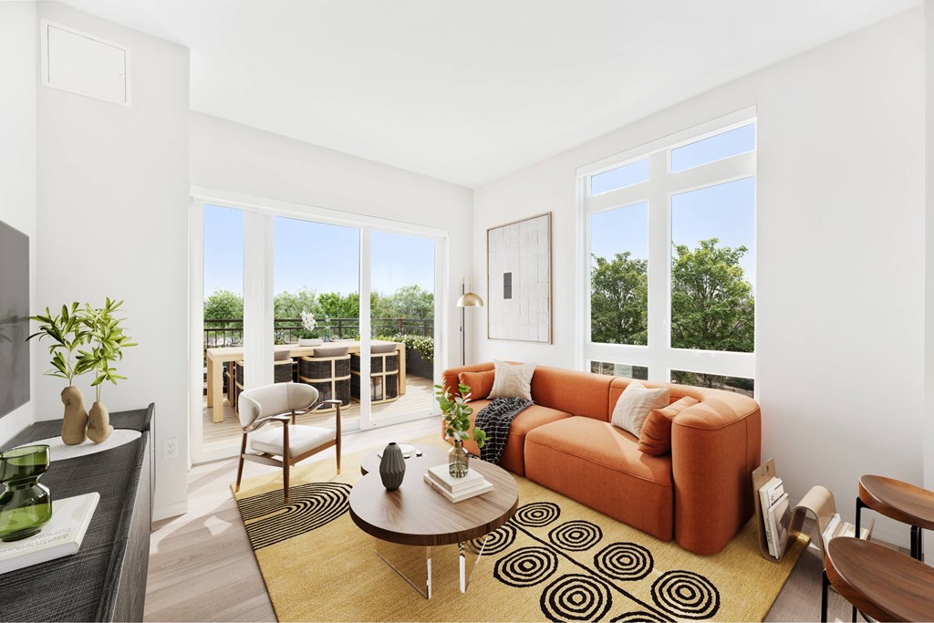 a living room with a orange couch and a large window