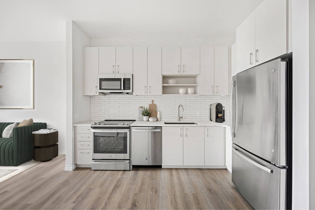 a kitchen with white cabinets and stainless steel appliances