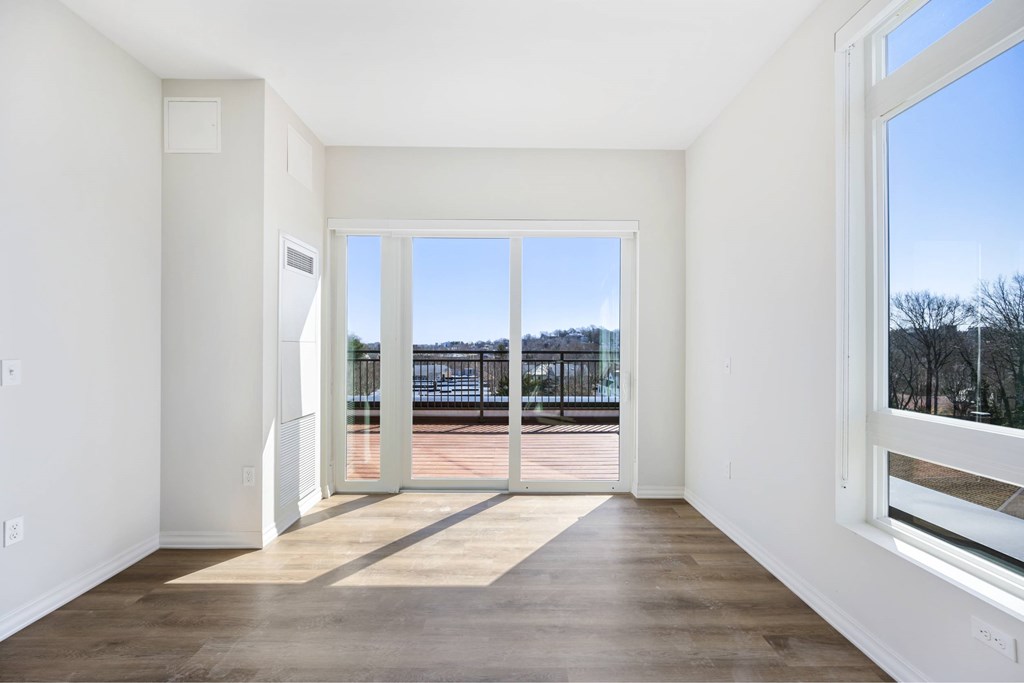 a living room with large windows and a wooden floor