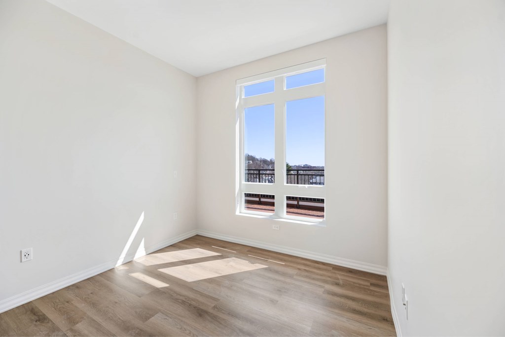 a living room with a window and hardwood floors